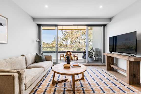 A living room with a couch, a coffee table, and a television.