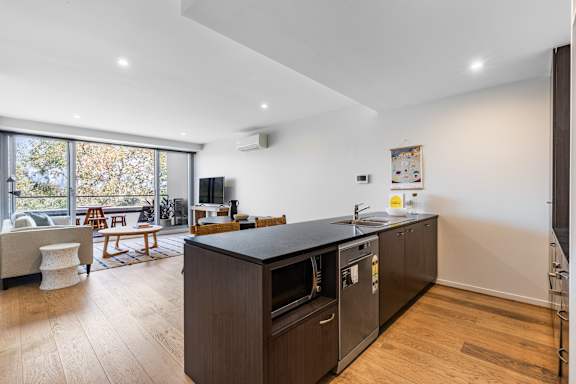 A modern kitchen with dark wood cabinets and a large island.