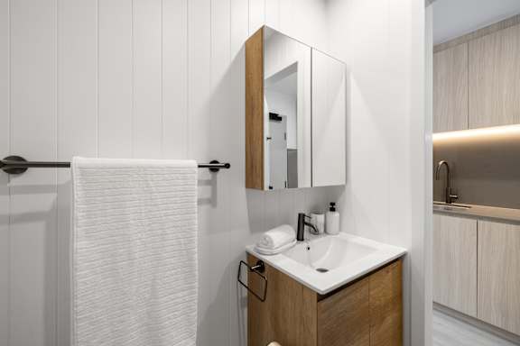 A bathroom with a white towel hanging on a towel rack.
