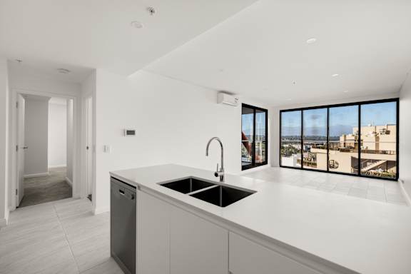 A modern kitchen with a large window overlooking the city.