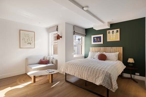 A bedroom with a bed, a couch, and a coffee table.