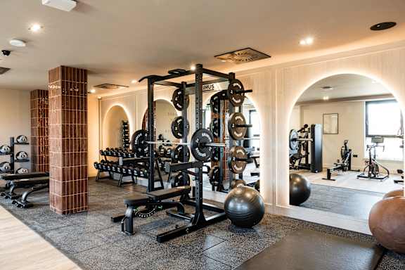 A gym with a variety of equipment including weights and machines.