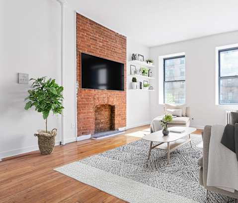 A living room with a fireplace and a tv on the wall.