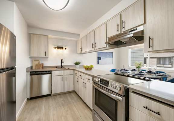 a kitchen with white cabinets and stainless steel appliances