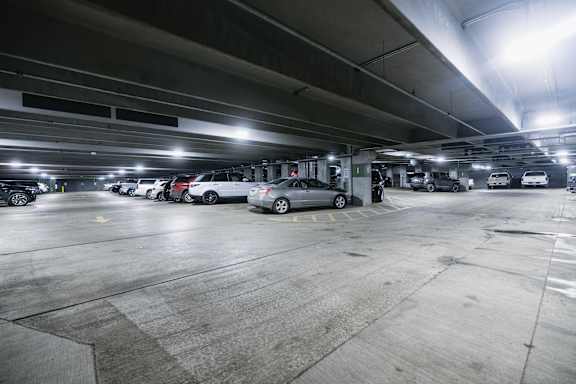 A parking garage with several cars parked.