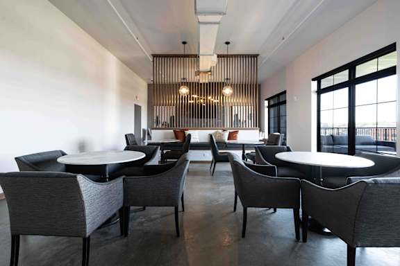 A restaurant with black chairs and tables.