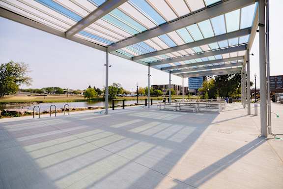 A large open area with a roof and a bench.