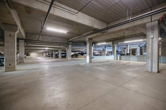 A large, empty parking garage with concrete floors and pillars.