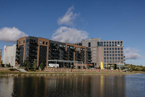 A modern building with a large body of water in front.
