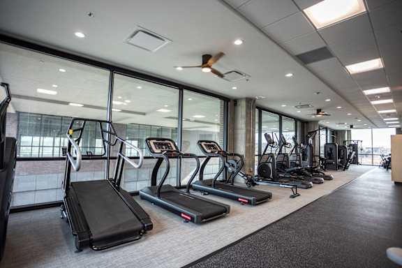 A gym with treadmills, elliptical machines, and other exercise equipment.