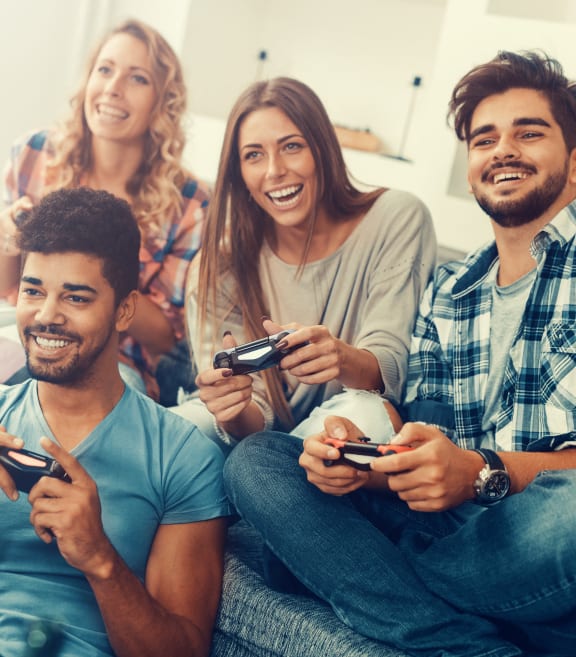a group of people sitting on a couch playing a video game at The Beck at Hidden River, Tampa, 33637