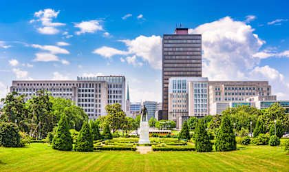 A large building with a tall white statue in front of it.