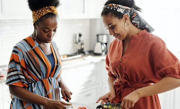 two women in the kitchen preparing a salad