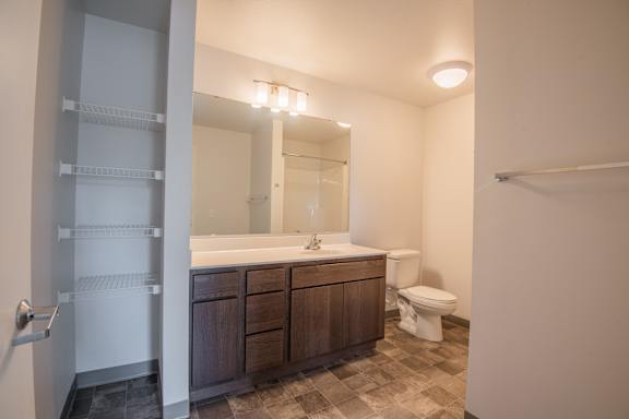 A bathroom with a toilet, sink, and mirror.