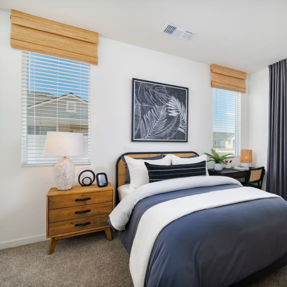 a bedroom with a bed and two windows