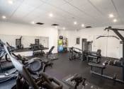 Thumbnail 5 of 8 - a gym with treadmills and other exercise equipment in a building with white walls