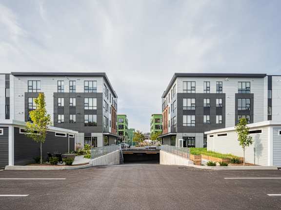 a group of new apartment buildings with a parking lot
