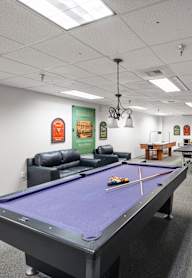 a game room with a pool table and two billiards tables