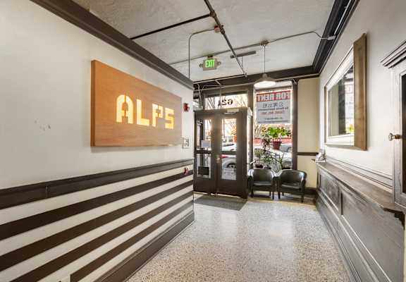 A hallway with a sign that says ALPS on the wall.