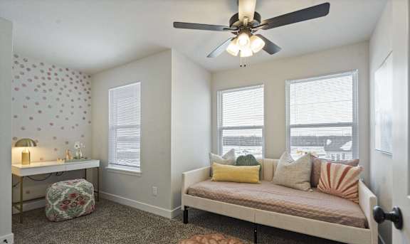 A modern living room with a beige couch and a glass coffee table.