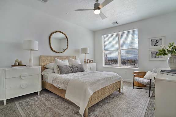A bedroom with a bed, dresser, and mirror.