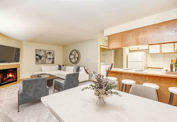 a living room with a fireplace and a table with chairs at Autumn Village, Washington, 98354