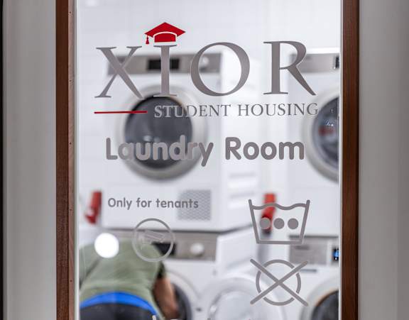 A window with a sign that says "Laundry Room Only for Tenants".