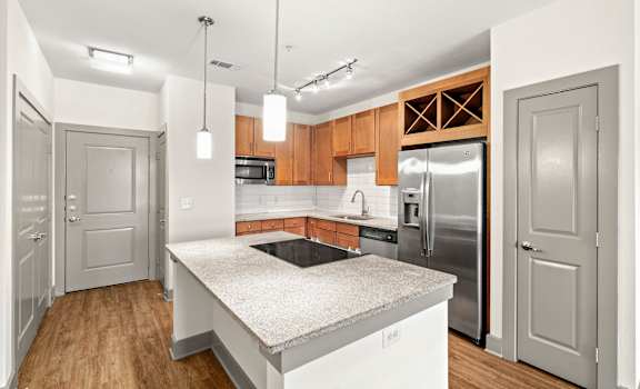 A kitchen with a granite countertop and stainless steel appliances.