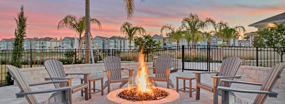 A large swimming pool in front of a house with lounge chairs and umbrellas.