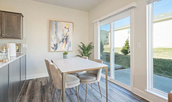 a dining area with a table and chairs and a sliding glass door