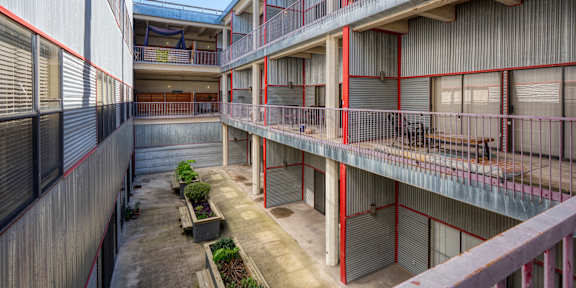 A courtyard with a concrete floor and a small garden in the middle.