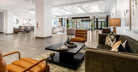 A modern living room with a black coffee table and a brown leather chair.