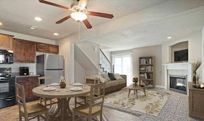 a living room and dining room with a table and chairs