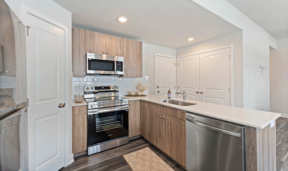 A modern kitchen with a stainless steel dishwasher and oven.