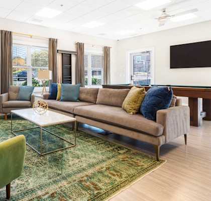a living room with a couch and chairs and a television