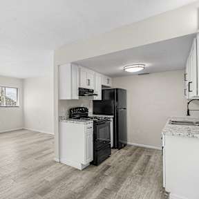 A kitchen with white appliances and cabinets.