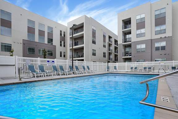 A swimming pool in front of apartment buildings.