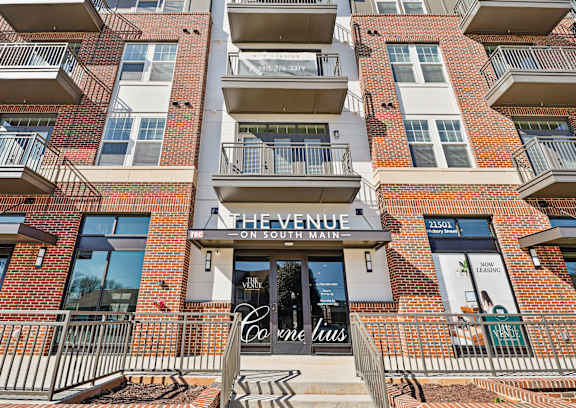 The Venue on South Main is a multi-story apartment building with balconies and a sign for Corrie Louise.