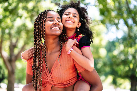 a mother and daughter smiling and hugging each other