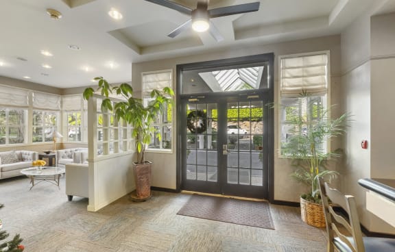 the lobby of a home with a glass door and a ceiling fan