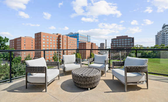 A patio with four chairs and a table with a view of a city skyline. at The Dorset, Kansas City, MO