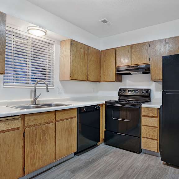 A kitchen with black appliances and wooden cabinets.