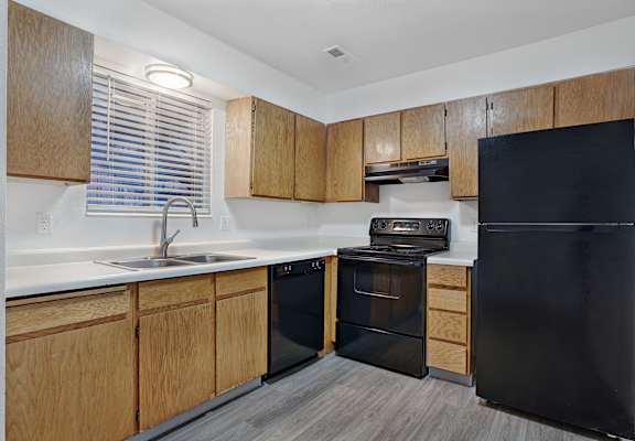A kitchen with black appliances and wooden cabinets.