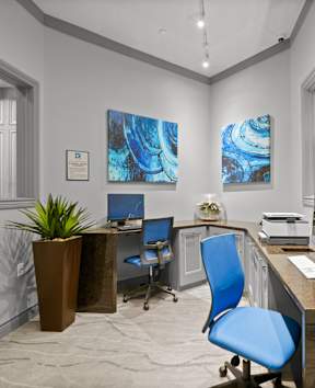 A modern office with a blue chair and a brown desk.
