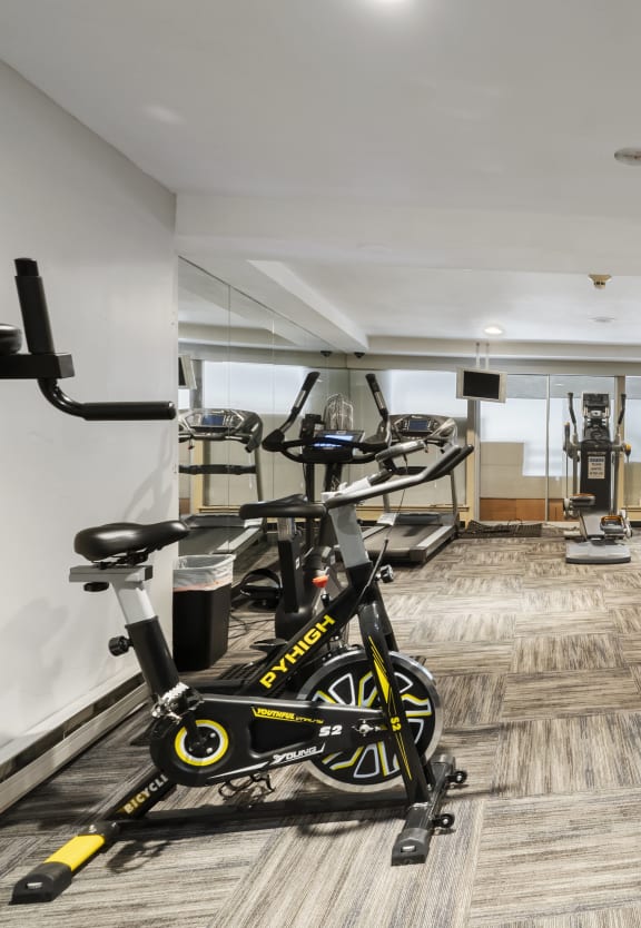 a gym with weights and bikes in the corner of a room