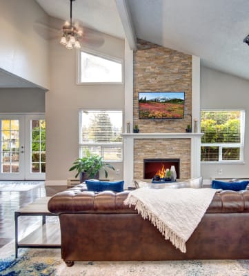 a living room with a leather couch and fireplace