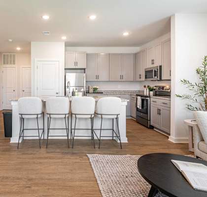 a kitchen and dining room with white chairs and a table