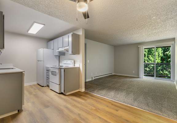 A kitchen with a refrigerator, microwave, and oven.