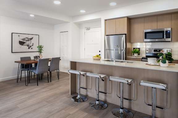 A modern kitchen with a bar stool in front of it.