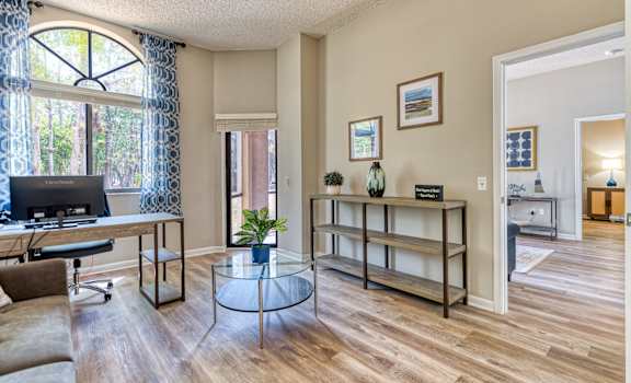 the living room of a home with a desk and a window